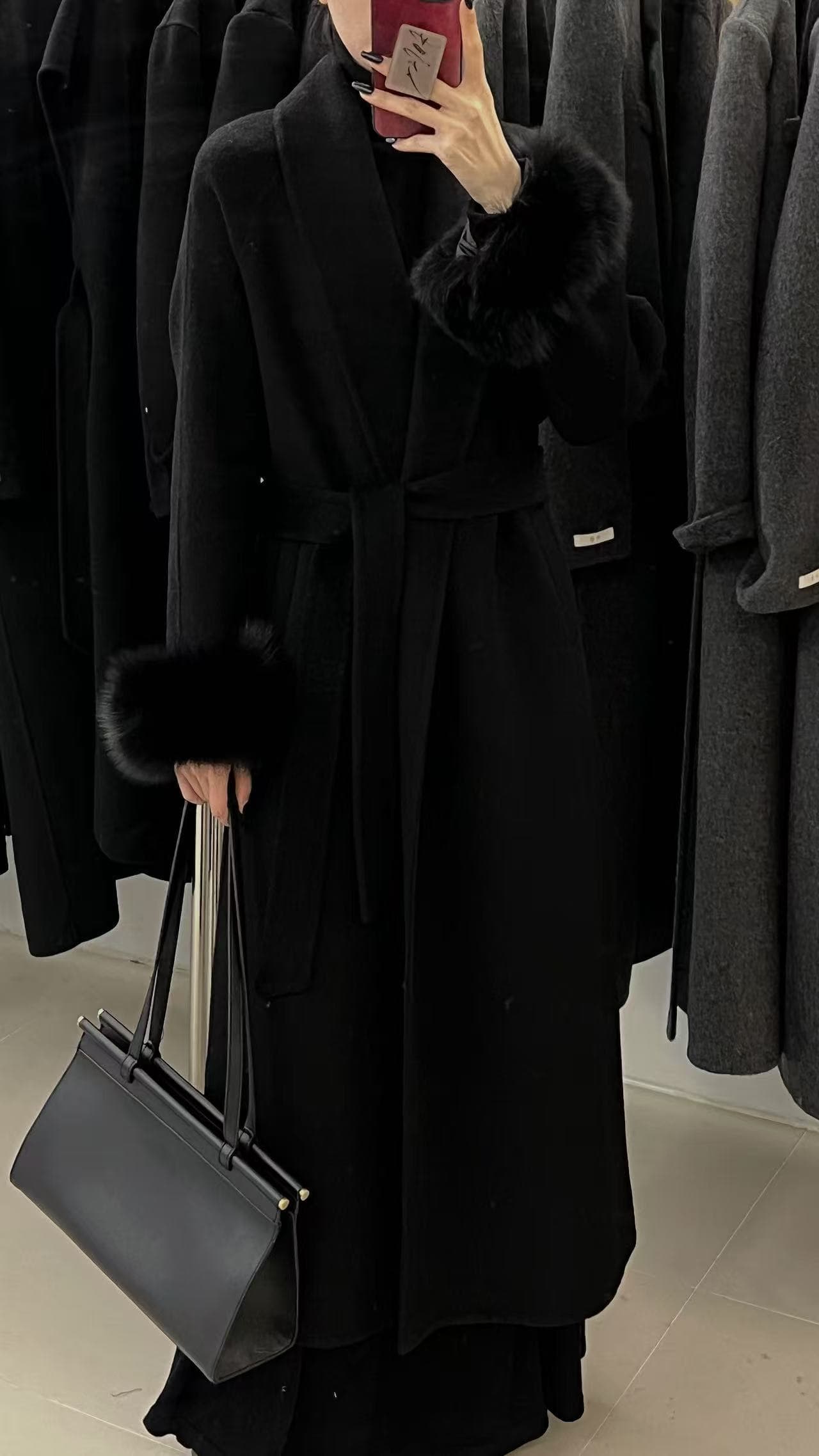 Black premium coat presented in a showroom mirror shot